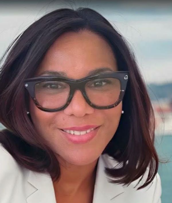 Woman with glasses smiling.