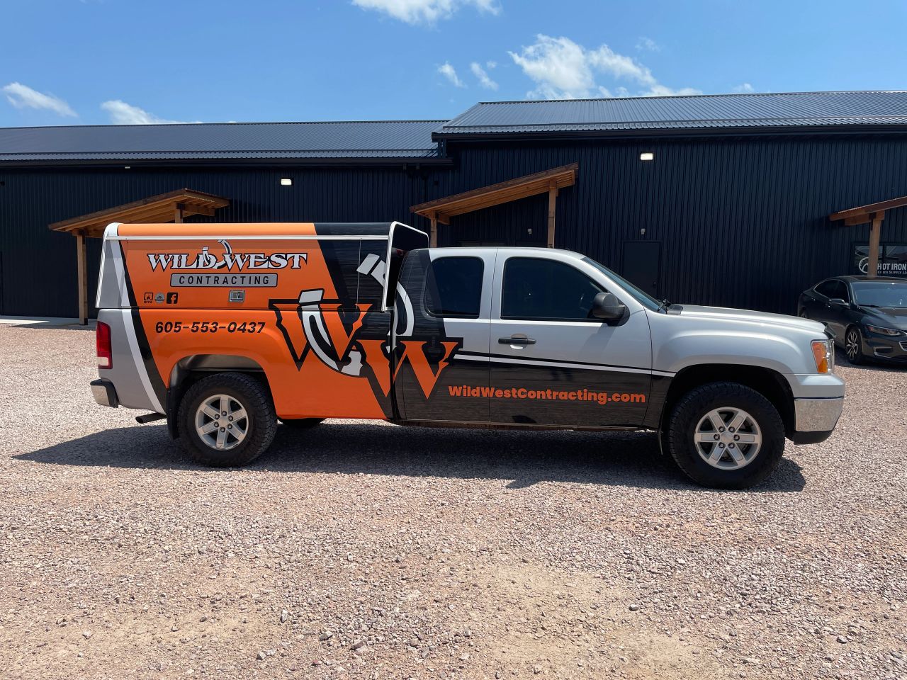 Wild West Contracting pickup with orange rear graphics and business lettering