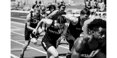 Runners sprinting intensely at the start of a track race.