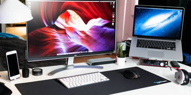 Modern dual-monitor workspace with laptop and desktop setup, sleek and organized.
