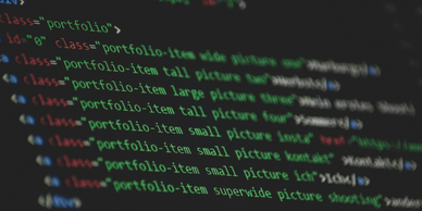 Close-up of HTML code for a portfolio section on a dark screen.
