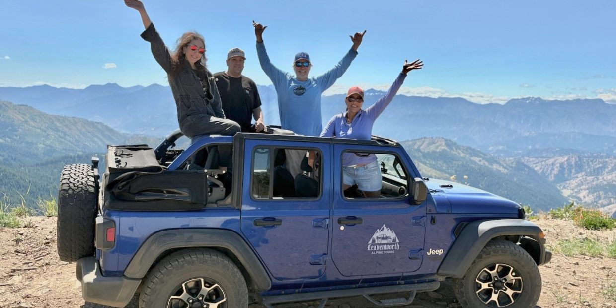 Guests enjoying a scenic Leavenworth Alpine Tours private Jeep tour at a Cascade Mountain summit overlooking the valley