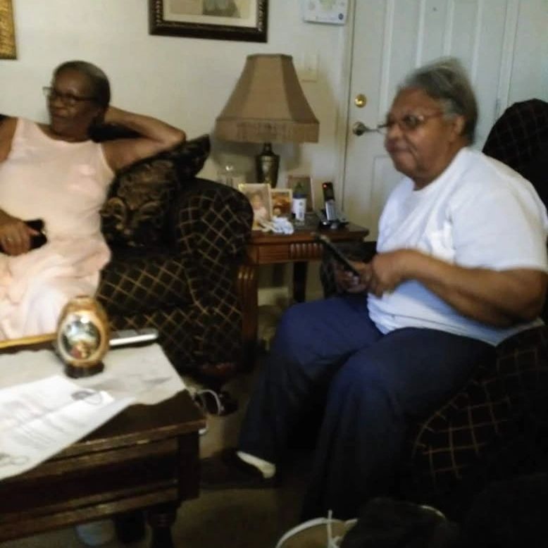 Two elderly women sitting and relaxing in a cozy living room.