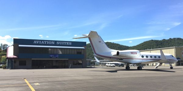 Private jet parked near Aviation Suites building.