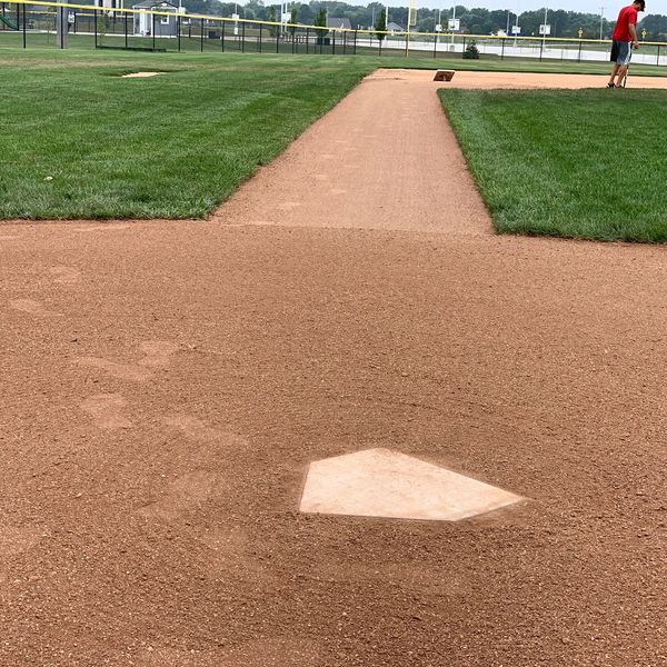 View of a baseball field's home plate and pitcher's mound area.