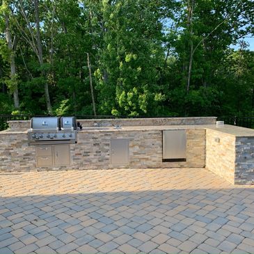 Outdoor kitchen/patio installation with granite countertops and ledgestone tile surround 