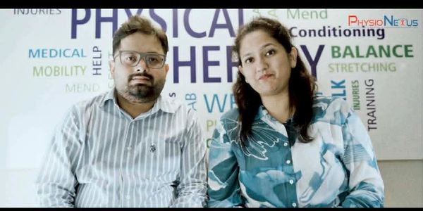 Two people sitting in front of a physical therapy word wall.