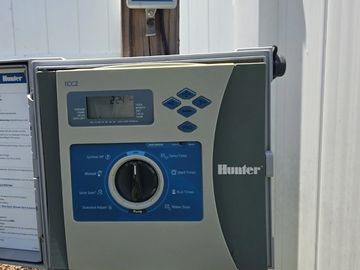 Hunter irrigation control panel and rain sensor mounted outdoors.