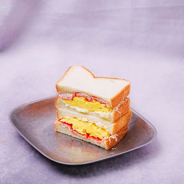 Soft scrambled eggs, crab stick, and creamy mayo slaw layered between fluffy milk bread.