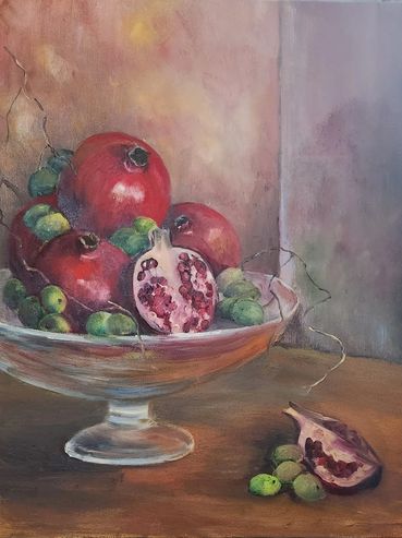 Still life painting of pomegranates and green olives on a glass pedestal bowl.