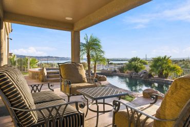 Cozy patio with seating overlooking pool and lake view.