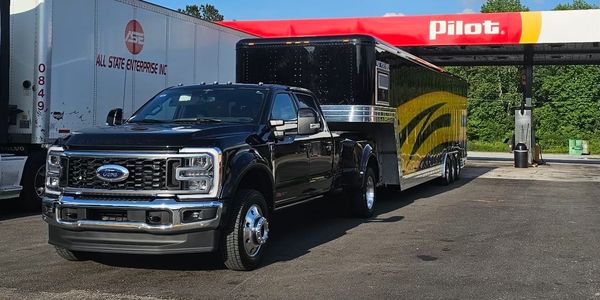 F-450 truck hauling a featherlight trailer carrying nascar products in a pilot parking lot 