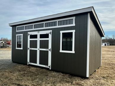 Modern dark gray shed with white trim and double doors.