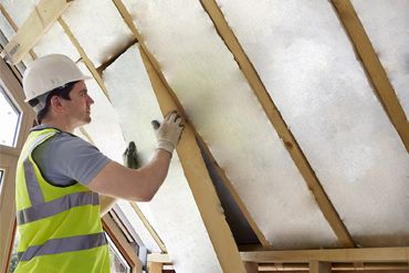 Construction worker placing cut insulation boards