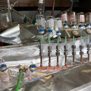 Laboratory setup with multiple glass vials and connected tubing.