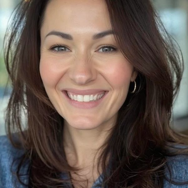 Smiling woman with brown hair and hoop earrings.