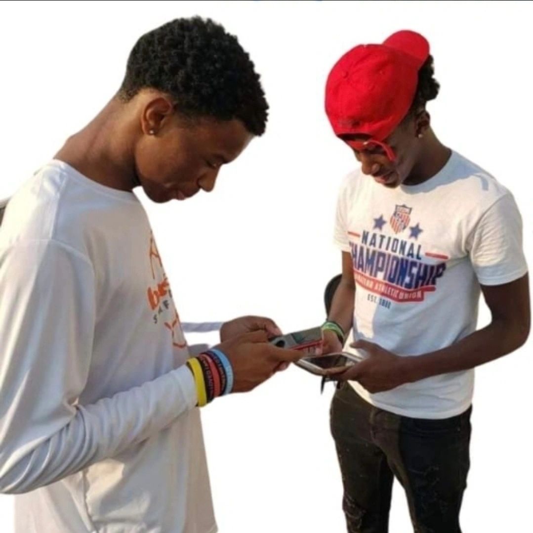 Two young men looking at their phones.