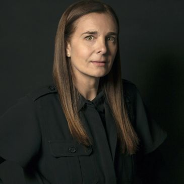 Portrait of a woman with long hair against a dark background.