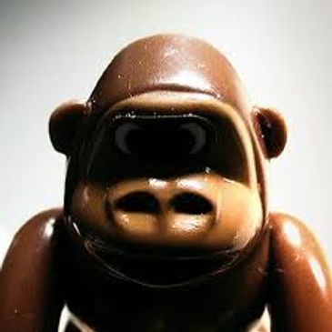 Close-up of a brown gorilla toy with a shiny surface.