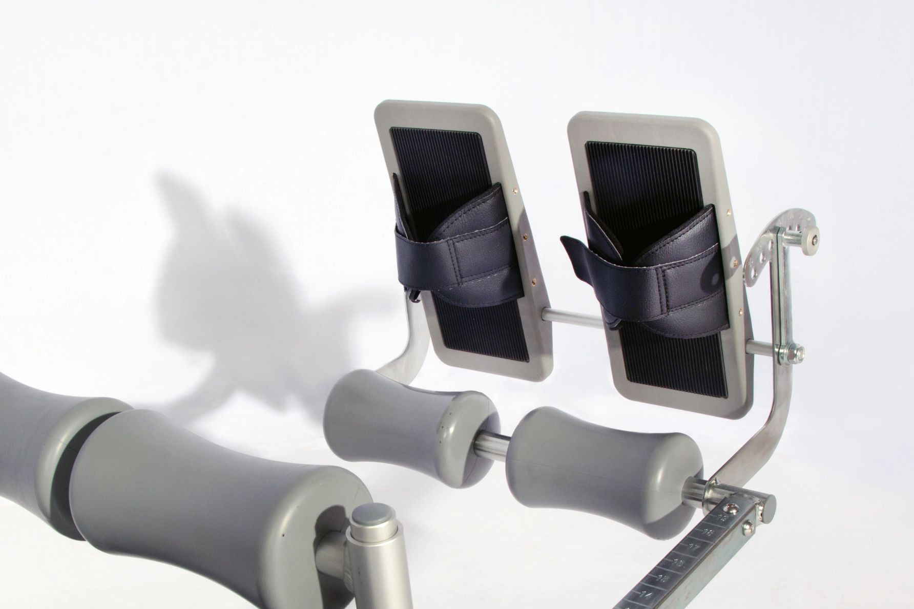 Close-up of leg support and footrests on exercise equipment.