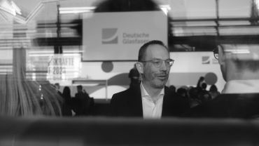 Mann im Anzug bei einer Veranstaltung, Schwarz-Weiß-Foto.