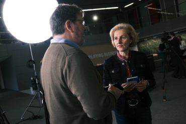 Zwei Personen führen ein Gespräch in einem Studio mit Studiolicht.