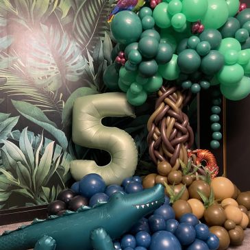 Balloon decoration with number 5, tree, and dinosaur.
