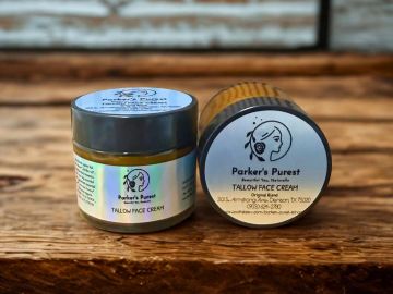 Two jars of Parker's Purest Tallow Face Cream on wooden surface.