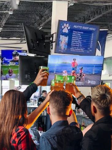 people cheering sports on TV at Mutts and Martinis Sports Bar