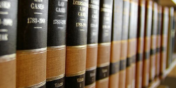 A row of American International Law Cases books on a library shelf.