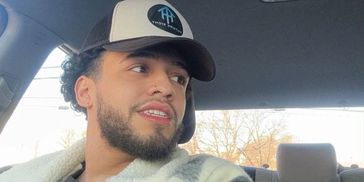 Young man wearing a cap inside a car.