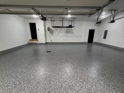 Minimalist room with white walls, black acoustic panels, and a textured ceiling.