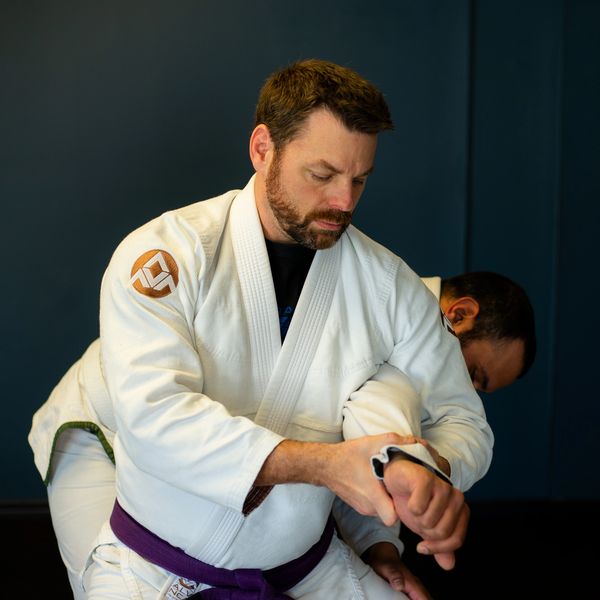 Brazilian Jiu Jitsu instructor demonstrating a standing armlock.