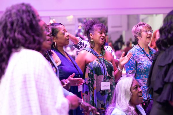 Women singing together in a group at an event.
