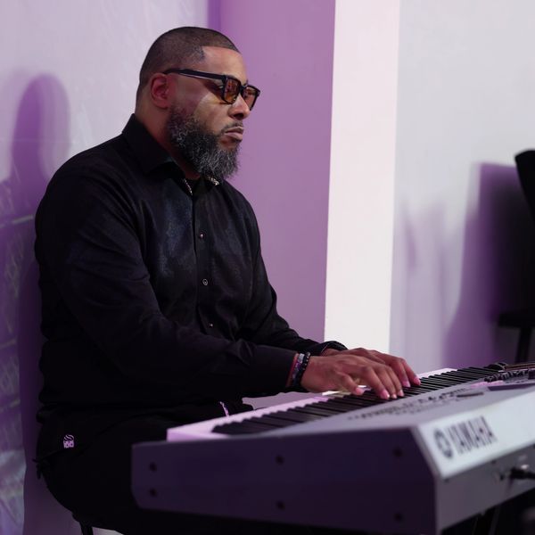Man playing keyboard in a focused manner.