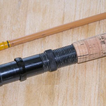 Close-up of a fishing rod handle on wooden surface.