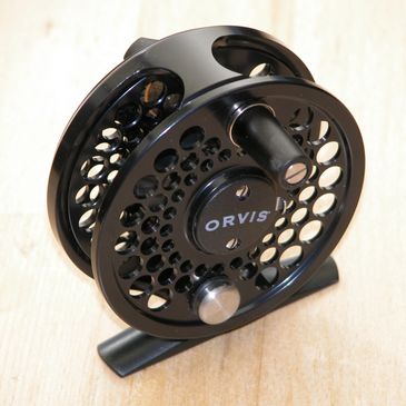 Black Orvis fishing reel with perforated design.