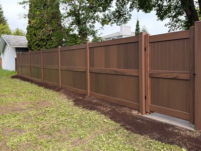 A long brown privacy fence with a gate.