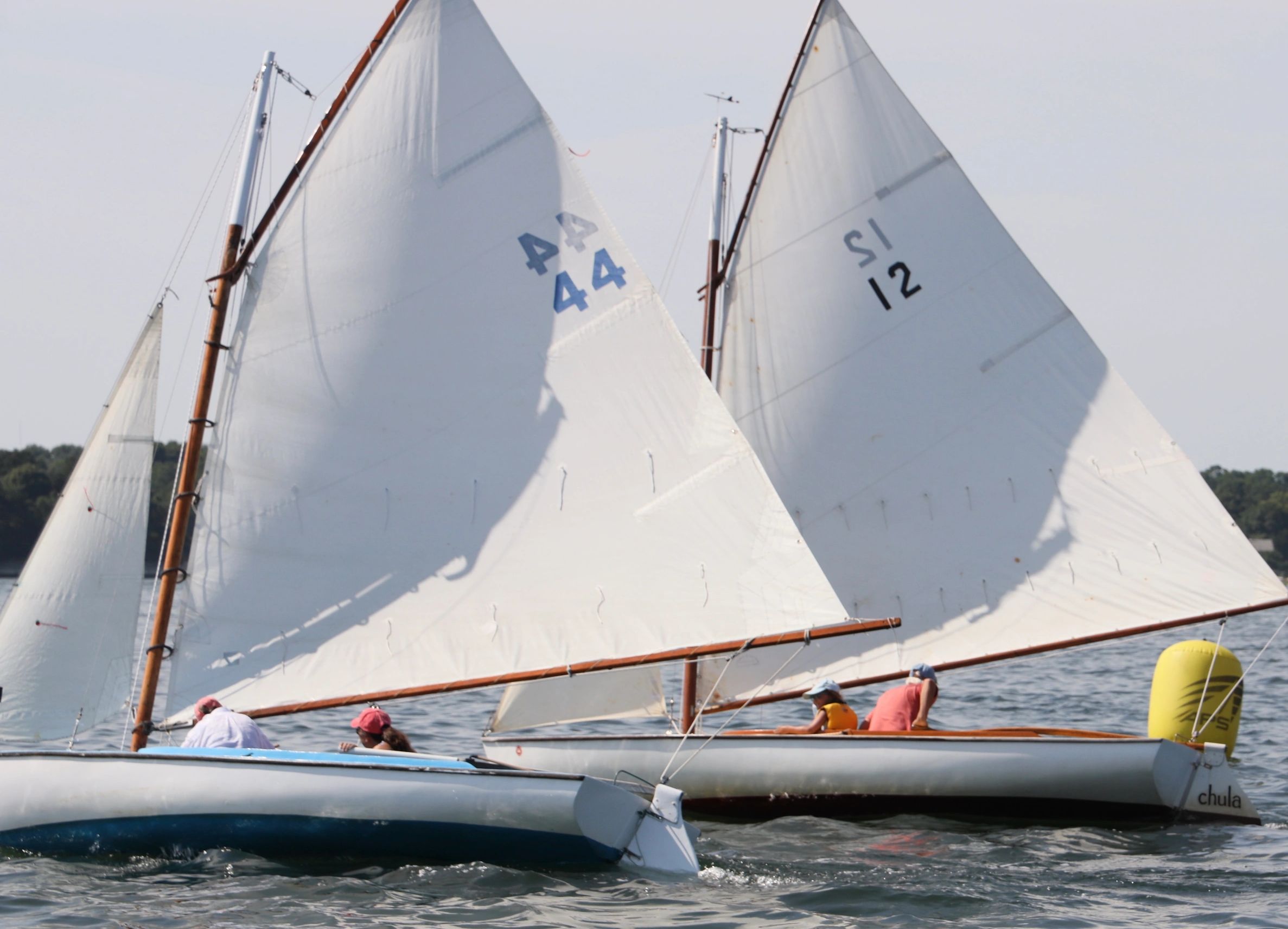 Two NSA BayBirds racing past a mark in the Sunday Adult Sailing program on Pleasant Bay