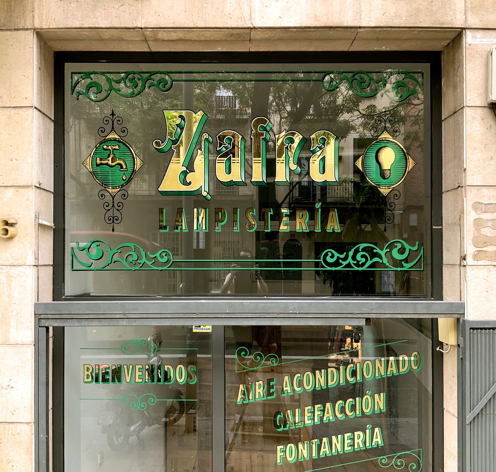 rotulación tradicional en oro 24klts sobre vidrio para lampistería en Sant Andreu en Barcelona