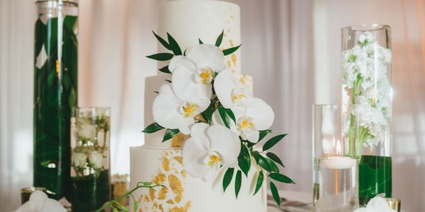 Candles and white wedding cake with flowers 