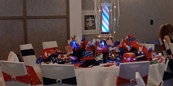 Patriotic-themed party table with American flags and red, white, and blue decorations.
