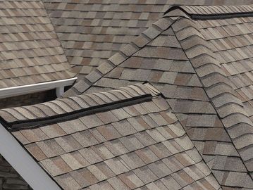 Close-up of a shingled roof with ventilation.