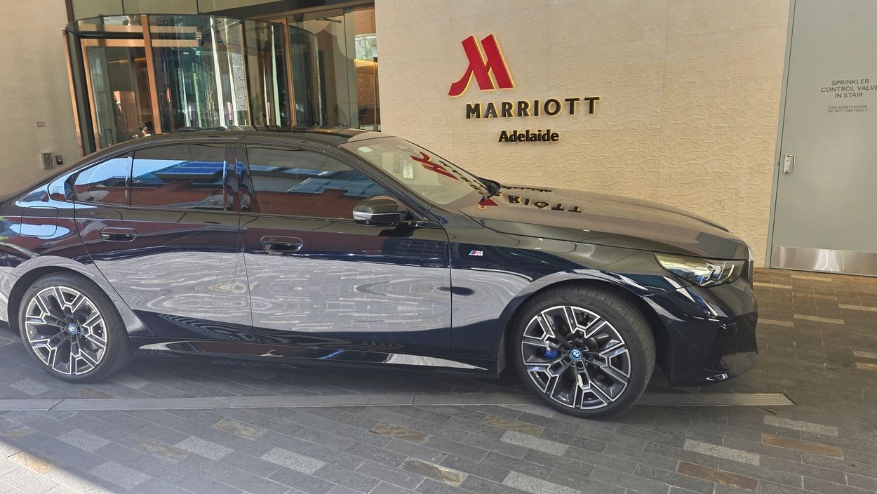 A sleek black BMW parked outside Marriott Adelaide hotel.