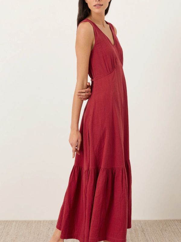 Woman wearing a sleeveless, deep red maxi dress with a V-neck.