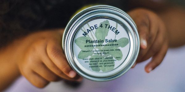 Daughter holding a 4 oz jar of Plantain Salve