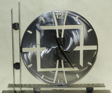 A polished steel mantle clock or wall hanging clock.  Sealed in gloss clear. 