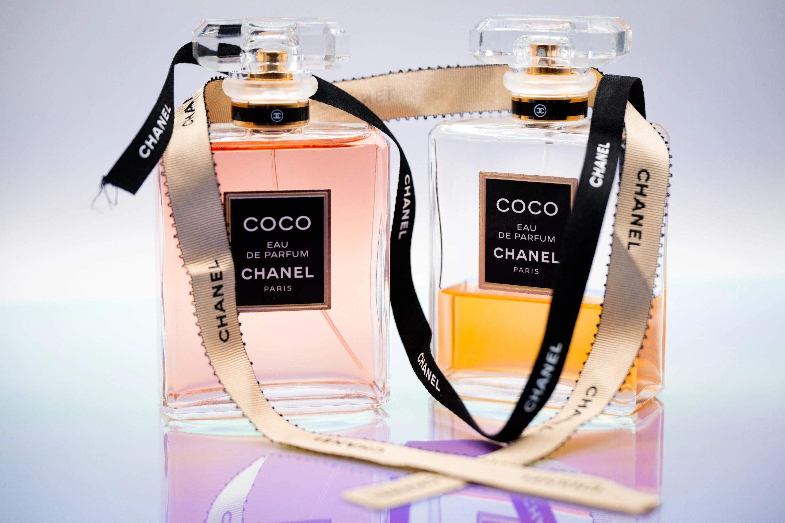 Two elegant Coco Chanel perfume bottles with decorative ribbons.
