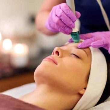 Woman receiving a facial treatment with a dermaroller.