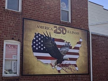 Mural celebrating America with a bald eagle and flag map.
